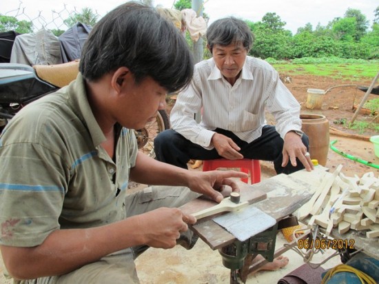 Nghệ nhân Võ Văn Hải (trái) đang hướng dẫn người làm kiểm tra các sản phẩm